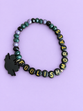 Green, lilac, and black beaded bracelet with gold lettering and a black charm